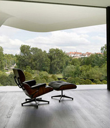 Design da poltrona Eames em nogueira com estofamento preto em Portugal.
